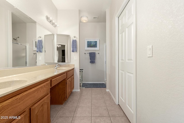 bathroom with tile patterned flooring, vanity, and an enclosed shower