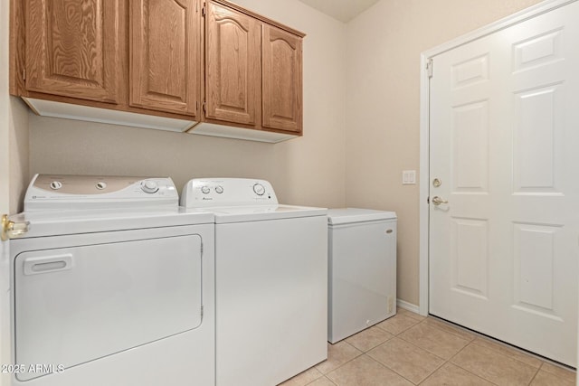 laundry room with cabinets, independent washer and dryer, and light tile patterned floors