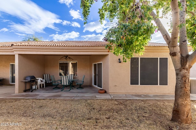 back of property featuring ceiling fan and a patio