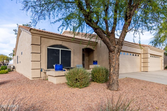 view of front of house with a garage and central AC