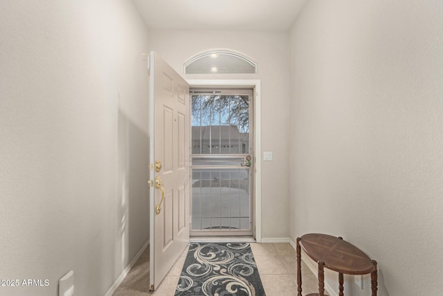 doorway to outside with light tile patterned floors