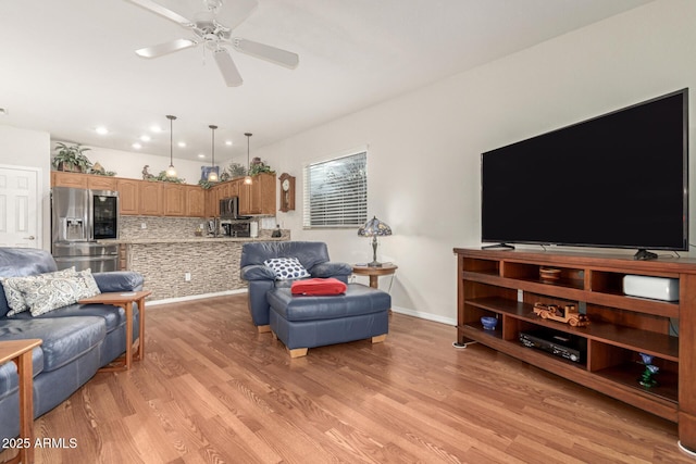 living room with light wood-type flooring and ceiling fan