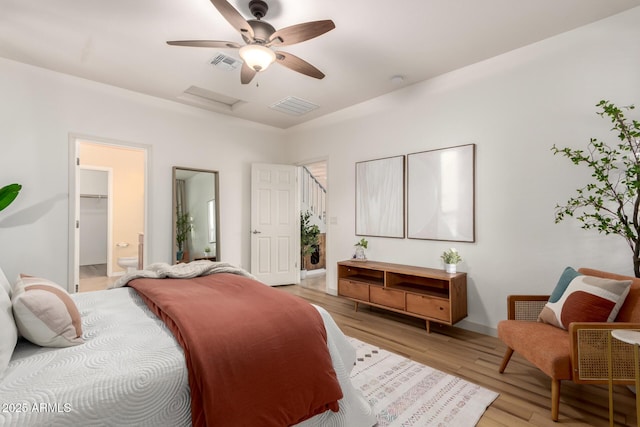 bedroom featuring ensuite bathroom, ceiling fan, and light wood-type flooring