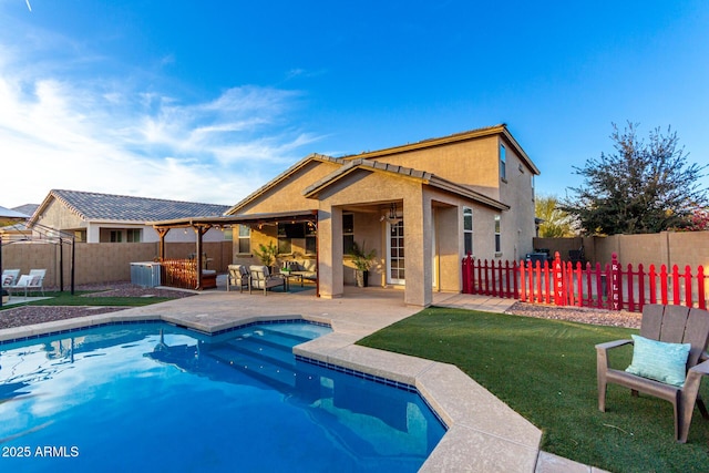 view of pool with an outdoor living space, a yard, a patio area, and central AC unit