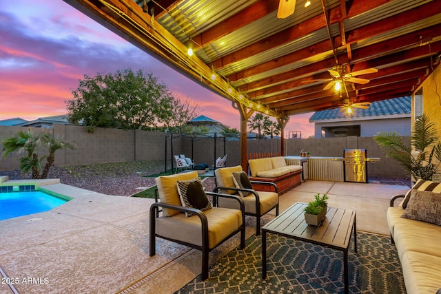 patio terrace at dusk with ceiling fan, outdoor lounge area, and a fenced in pool