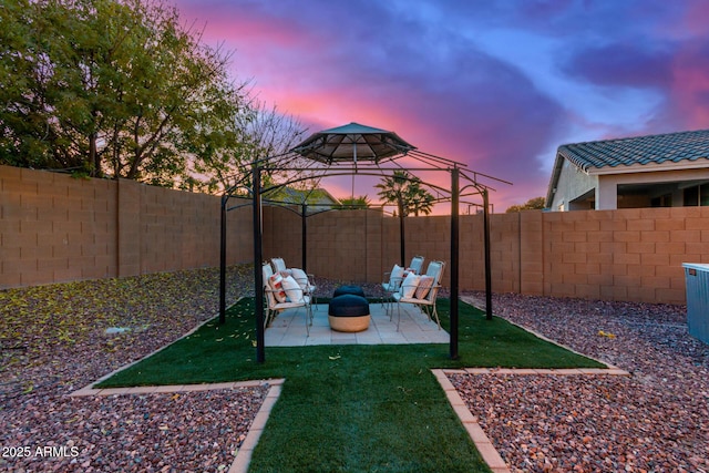 yard at dusk featuring a patio