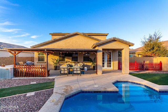 back of house featuring an outdoor hangout area, a patio area, and a fenced in pool