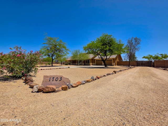 exterior space with fence, driveway, and a garage