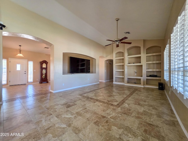 unfurnished living room with baseboards, visible vents, built in features, and ceiling fan