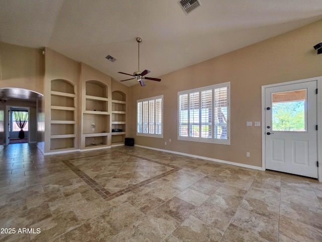unfurnished living room with ceiling fan, visible vents, built in features, arched walkways, and baseboards