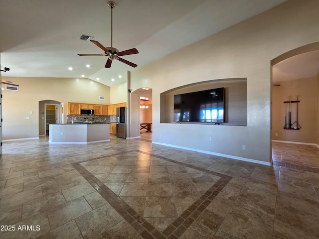 unfurnished living room with arched walkways, high vaulted ceiling, a ceiling fan, baseboards, and visible vents