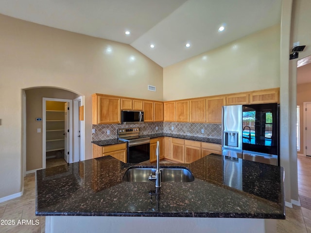kitchen featuring appliances with stainless steel finishes, tasteful backsplash, a spacious island, a sink, and high vaulted ceiling