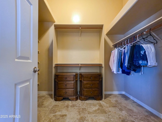walk in closet with stone finish floor