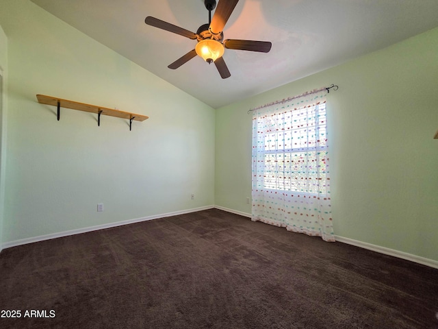 empty room with ceiling fan, baseboards, vaulted ceiling, and dark carpet