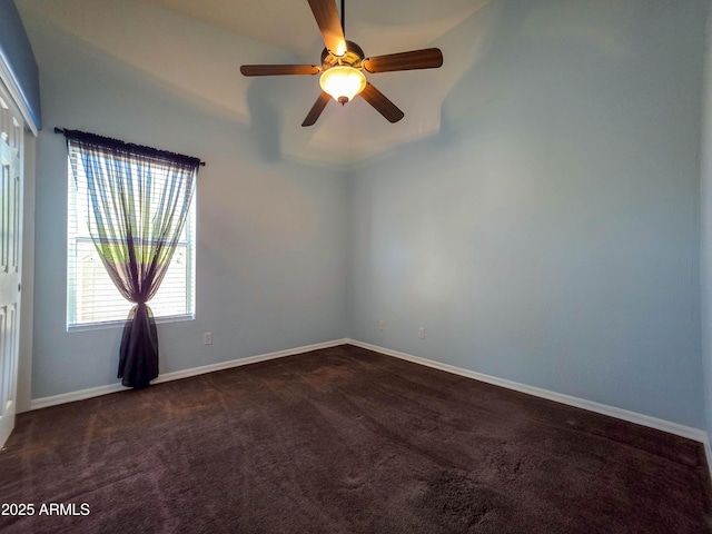 unfurnished room with baseboards, ceiling fan, and dark colored carpet