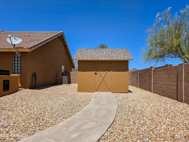 view of side of property with a storage shed, an outdoor structure, a fenced backyard, and stucco siding