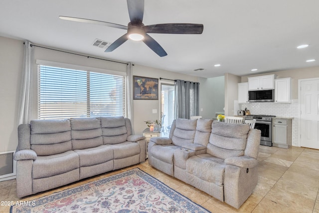 tiled living room with a healthy amount of sunlight and ceiling fan