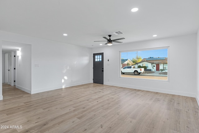 unfurnished living room featuring ceiling fan and light hardwood / wood-style flooring