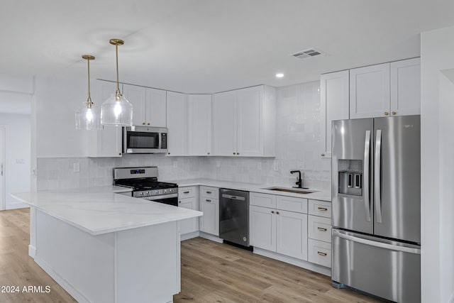 kitchen with kitchen peninsula, appliances with stainless steel finishes, sink, light hardwood / wood-style flooring, and white cabinetry