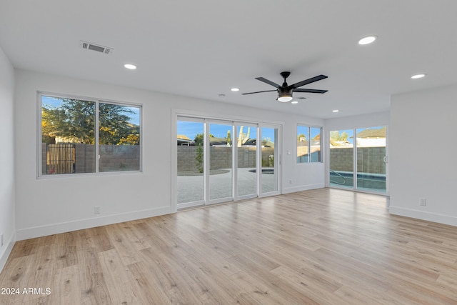 unfurnished room featuring ceiling fan, a healthy amount of sunlight, and light wood-type flooring