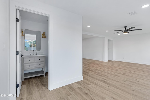 unfurnished room with ceiling fan, sink, and light hardwood / wood-style flooring