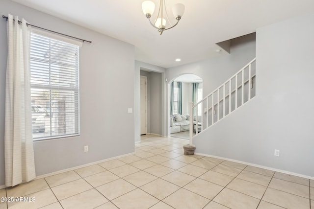 tiled entryway featuring an inviting chandelier and plenty of natural light