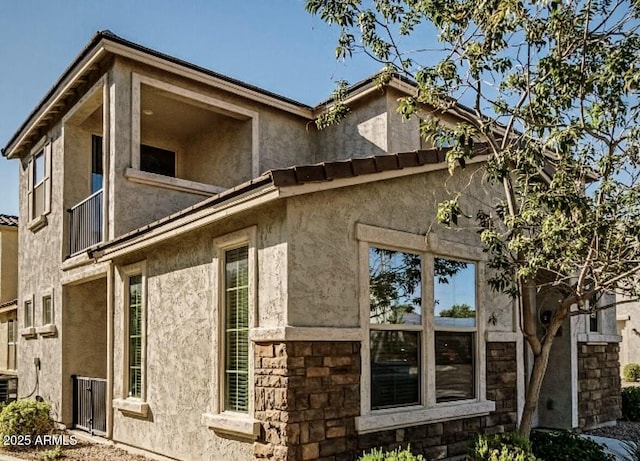 view of side of home featuring a balcony