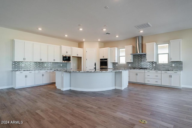 kitchen with white cabinetry and wall chimney exhaust hood