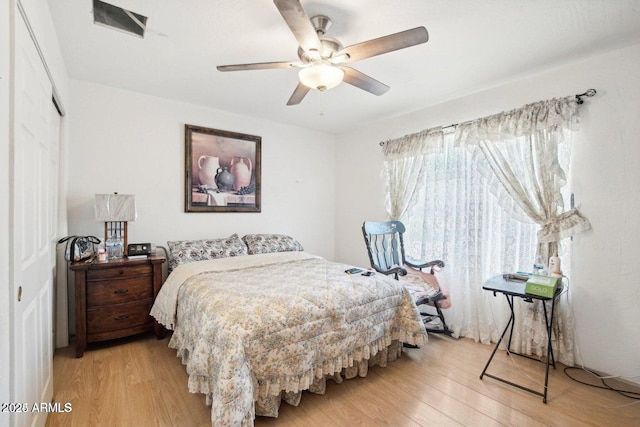 8343 W Calle Lejos, Peoria, AZ 85383 - bedroom with light wood-style flooring, a closet, and ceiling fan