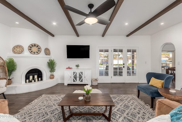 living room featuring dark wood-type flooring, plenty of natural light, and beam ceiling