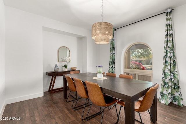 dining room with dark hardwood / wood-style floors and a chandelier