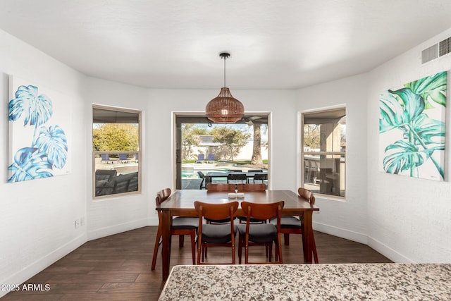 dining space with dark wood-type flooring and plenty of natural light