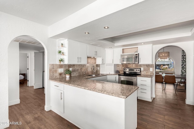 kitchen featuring stainless steel appliances, sink, white cabinets, and a tray ceiling