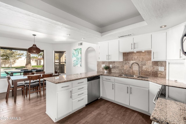 kitchen featuring white cabinetry, sink, hanging light fixtures, stainless steel dishwasher, and kitchen peninsula