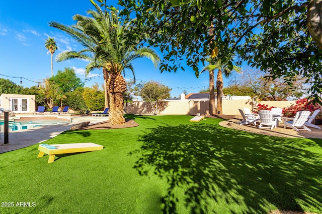 view of yard with an outdoor structure, a fenced in pool, and a patio area