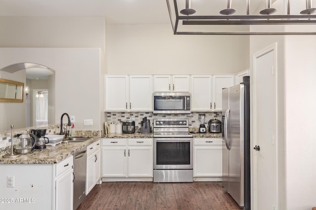 3821 N 125th Dr, Avondale, AZ 85392 - kitchen featuring appliances with stainless steel finishes, a peninsula, white cabinetry, and light stone countertops