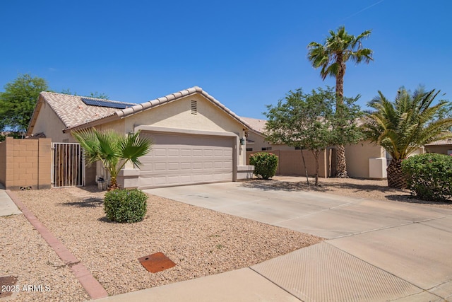 3821 N 125th Dr, Avondale, AZ 85392 - ranch-style home with solar panels, an attached garage, stucco siding, a gate, and concrete driveway
