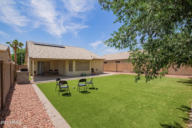 3821 N 125th Dr, Avondale, AZ 85392 - back of property featuring solar panels, a fenced backyard, a patio, and stucco siding