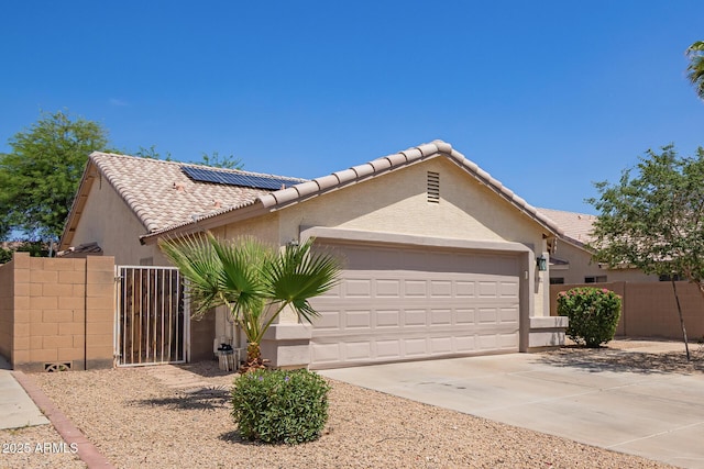 3821 N 125th Dr, Avondale, AZ 85392 - view of front of property featuring a garage, roof mounted solar panels, a tiled roof, and stucco siding
