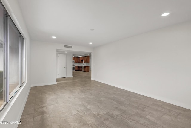 unfurnished room with baseboards, visible vents, and recessed lighting