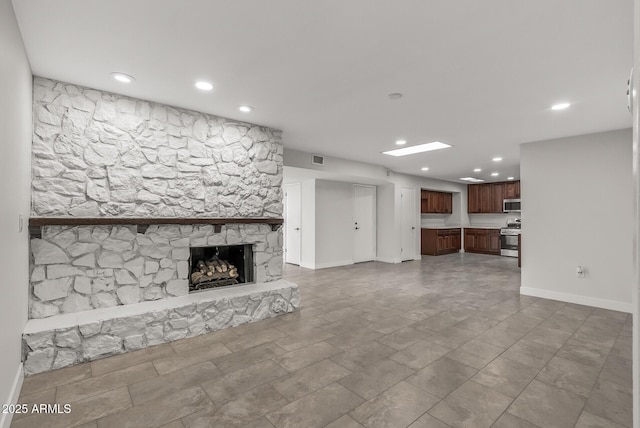 unfurnished living room featuring baseboards, a fireplace, visible vents, and recessed lighting