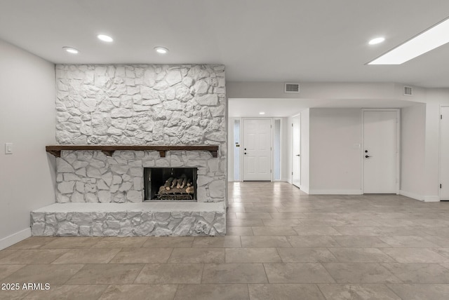 unfurnished living room featuring baseboards, a fireplace, visible vents, and recessed lighting