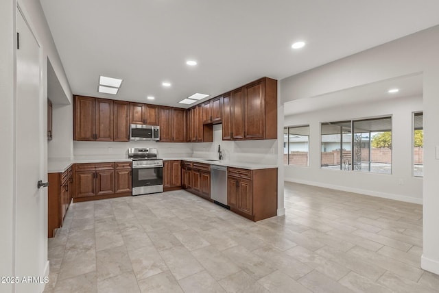 kitchen featuring light countertops, a sink, stainless steel appliances, and recessed lighting