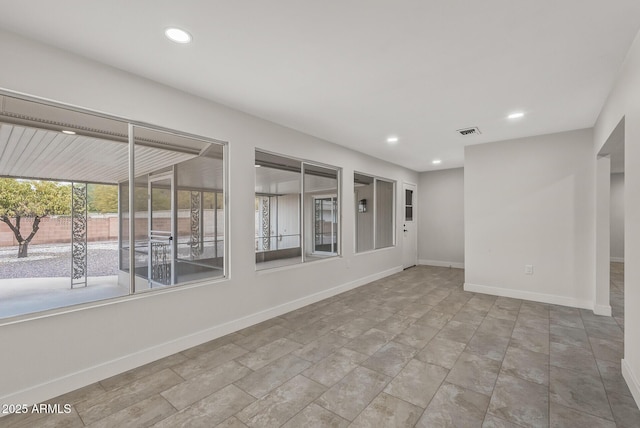 empty room featuring baseboards, visible vents, and recessed lighting