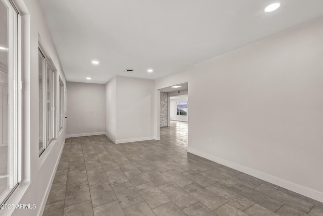 empty room with baseboards, visible vents, and recessed lighting