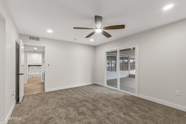 empty room featuring visible vents, recessed lighting, ceiling fan, and carpet