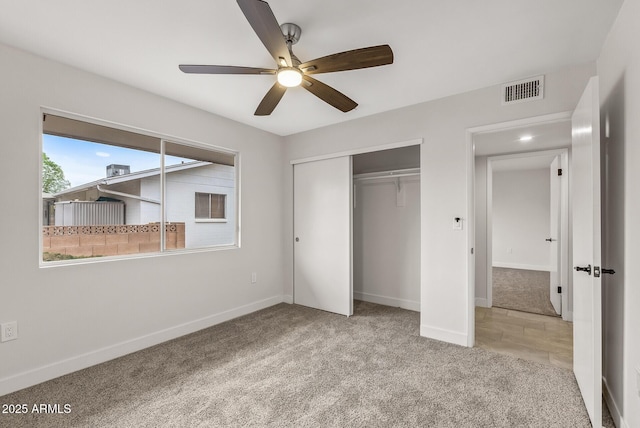 unfurnished bedroom with a closet, carpet flooring, visible vents, and baseboards
