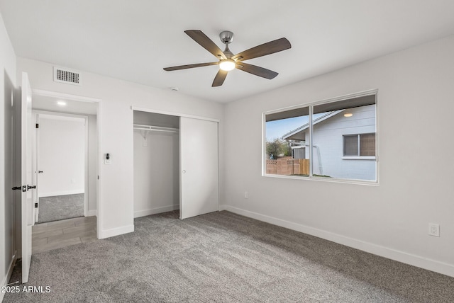 unfurnished bedroom with baseboards, visible vents, a closet, and carpet