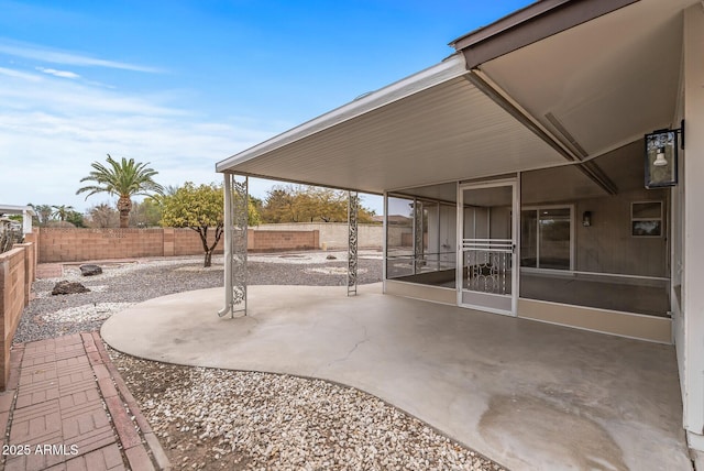 view of patio with a fenced backyard and a sunroom