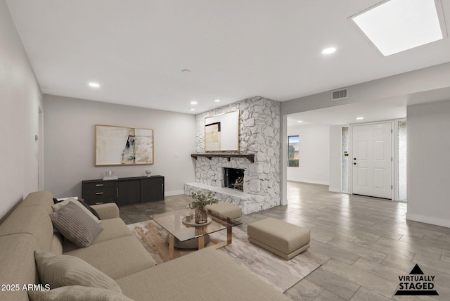 living area featuring baseboards, visible vents, recessed lighting, and a fireplace